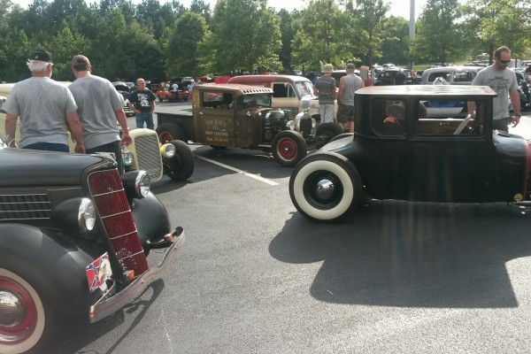 a group of hotrods at a car show