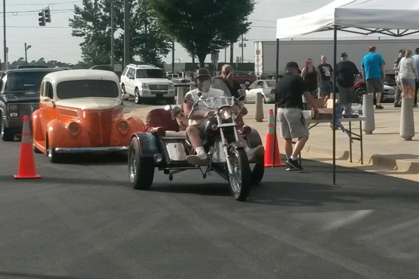 a motorcycle trike entering a hot rod show