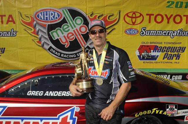 greg anderson holds wally trophy after nhra pro stock victory