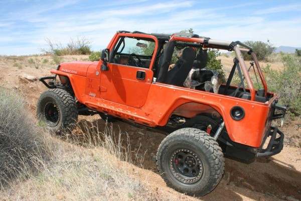 a jeep wrangler driving on a desert trail