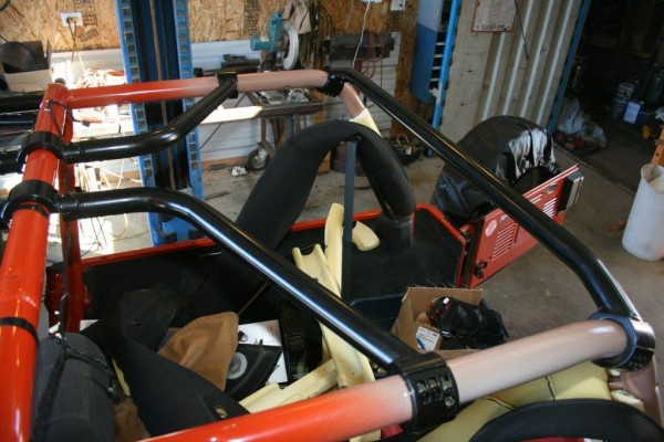 aftermarket rollcage getting installed on a jeep wrangler tj