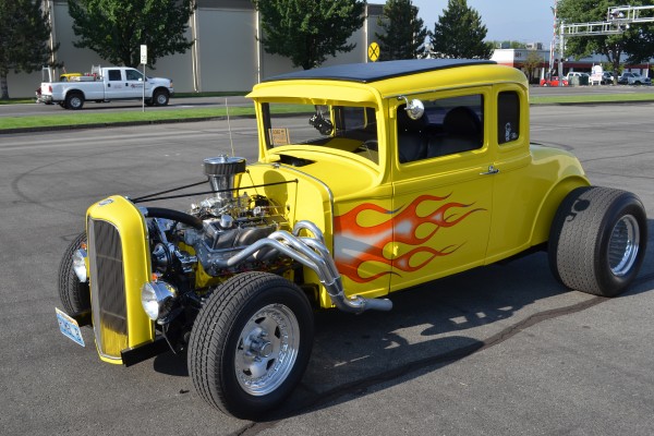 yellow ford five window hot rod coupe with flames
