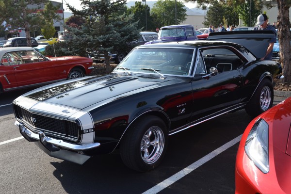 1967 chevy camaro ss with custom wheels at a cruise in