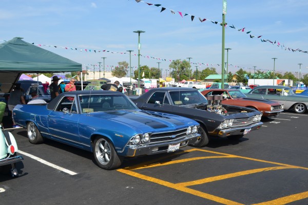 a par of chevy el camino hot rods parked at a cruise in