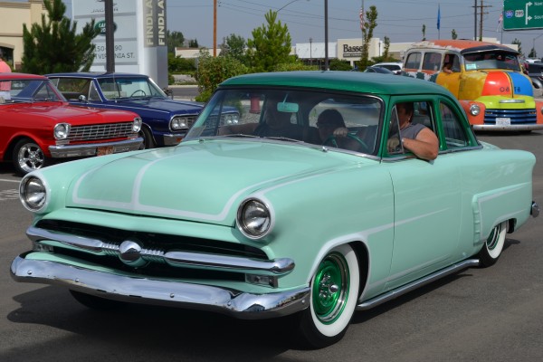 vintage plymouth 1950s coupe entering parking lot of a car show