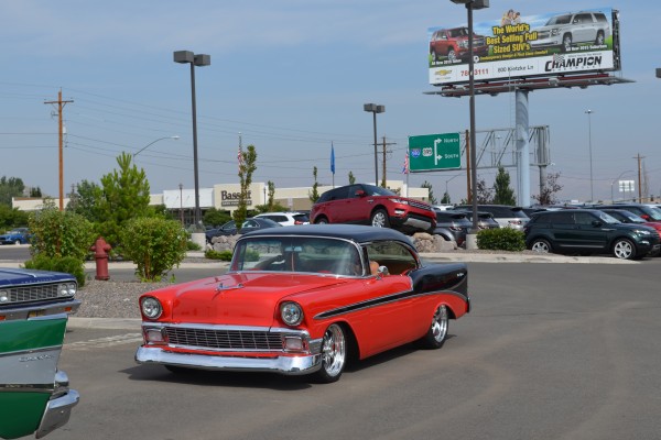 1956 chevy custom coupe entering parking lot of a car show