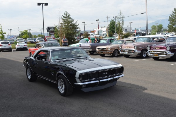 1967 chevy camaro ss entering parking lot of a car show