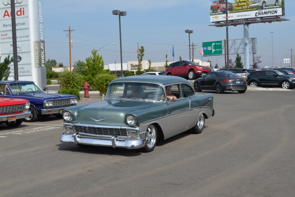 1956 chevy coupe entering parking lot of a car show