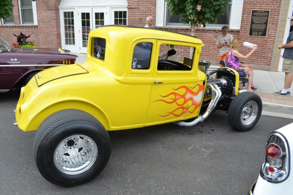 classic yellow ford five window hot rod parked on street