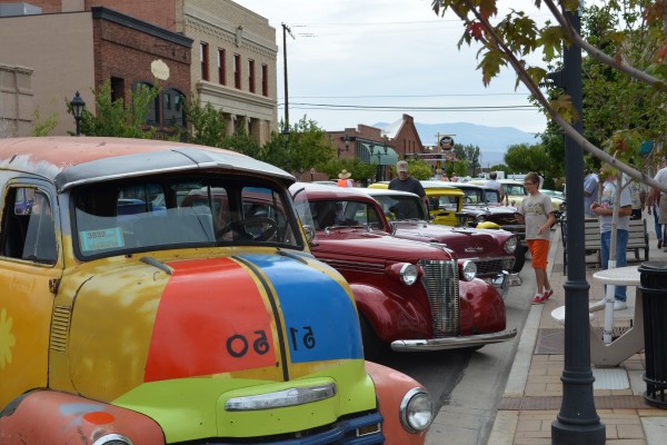 classic hot rods parked on street of a small town