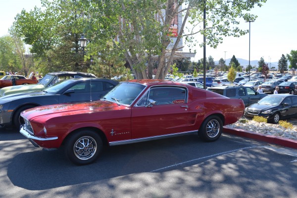 vintage 1968 fastback red ford mustang at a car show