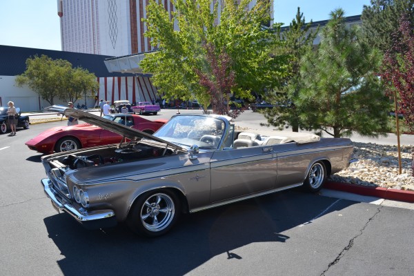 1960s era chrysler convertible parked at a cruise in
