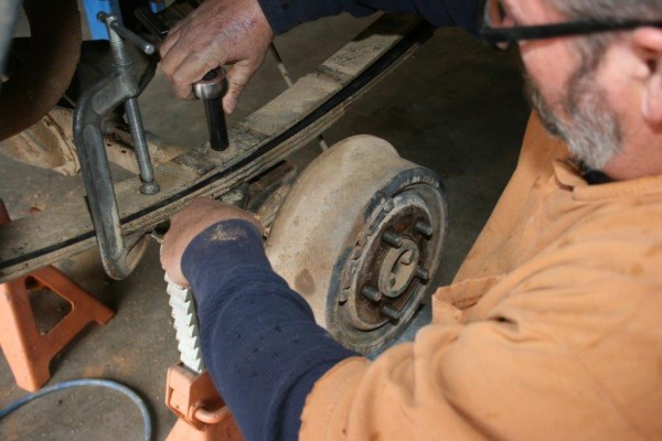 man removing leaf spring from a jeep cherokee xj