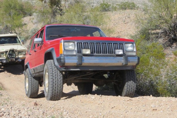 cherokee jeep xj climbing up a desert trail