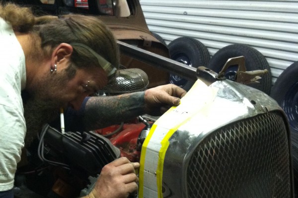 man making template for a custom hot rod radiator cowl