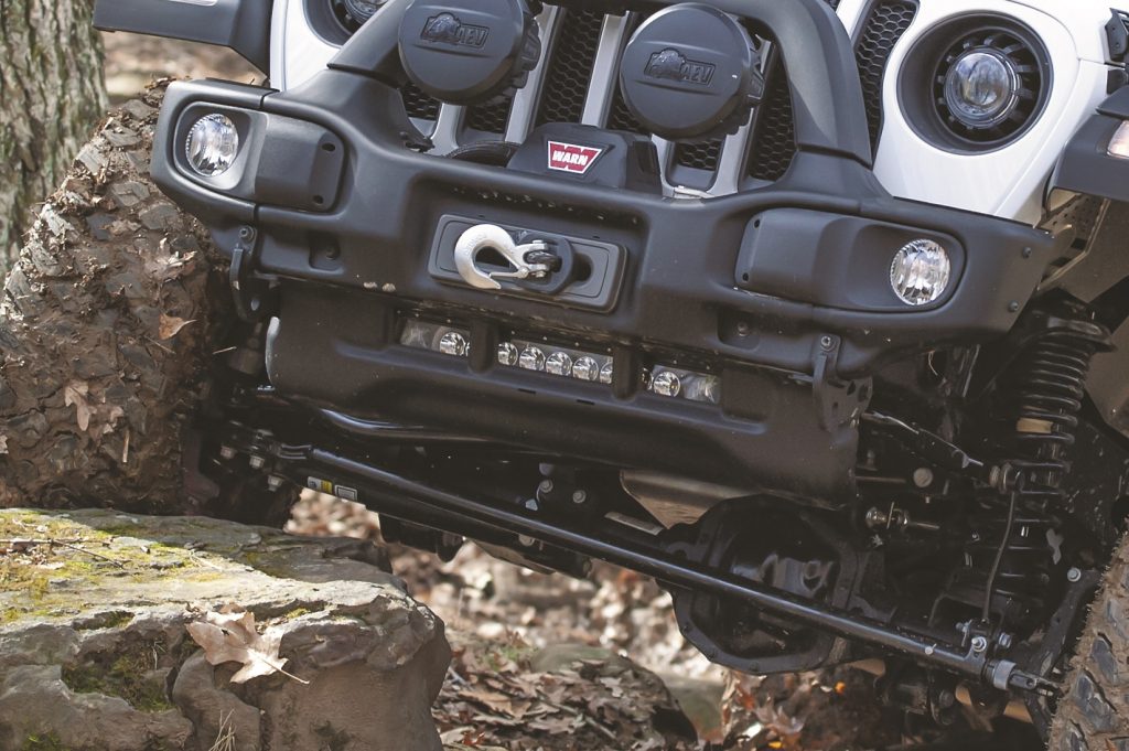 close up of front suspension articulation on a Jeep Wrangler as it climbs a hill