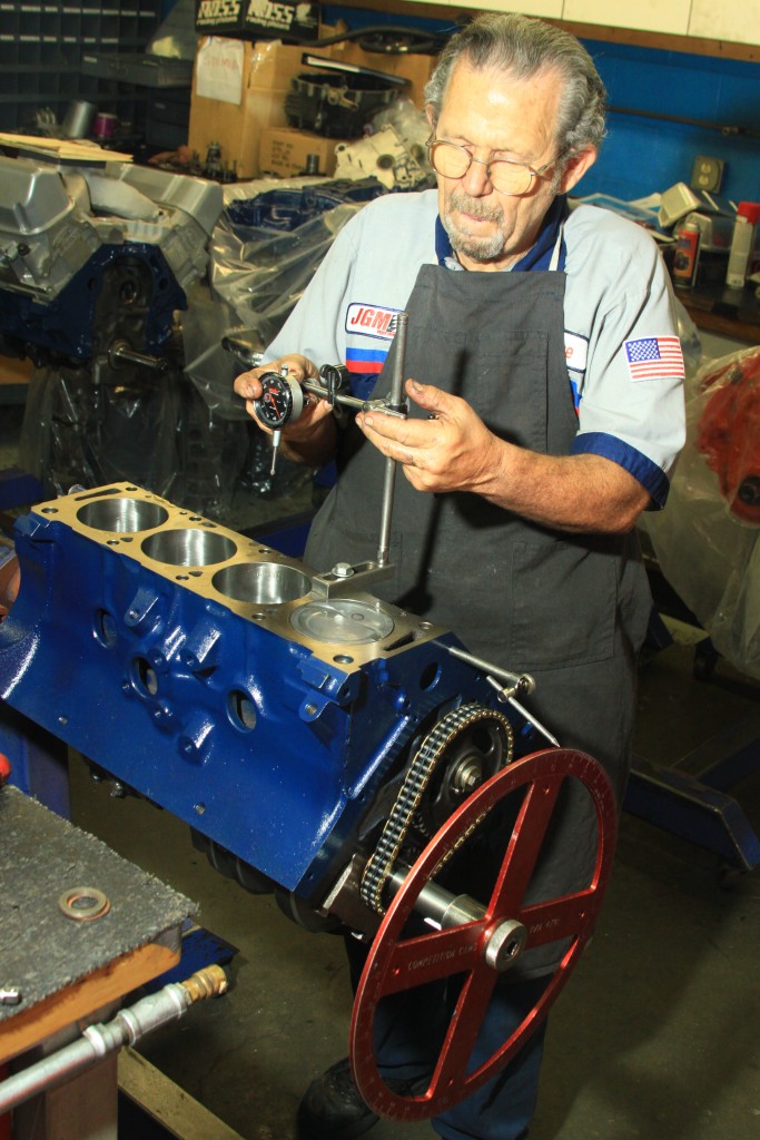 man checking piston travel in a ford fe engine