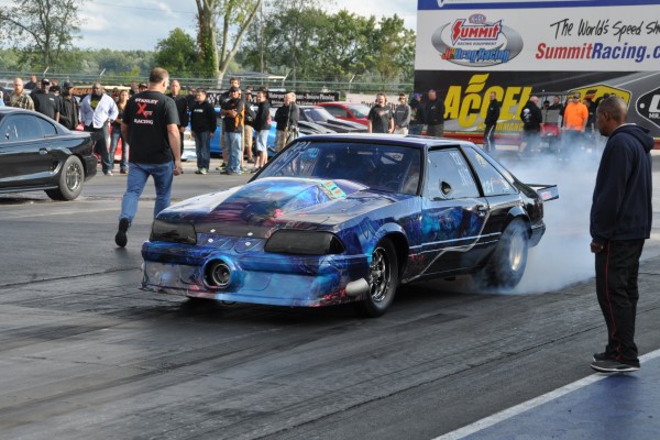 ford foxbody mustang doing a burnout at a drag strip
