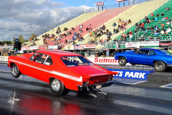 two chevy nova muscle cars launching at drag strip