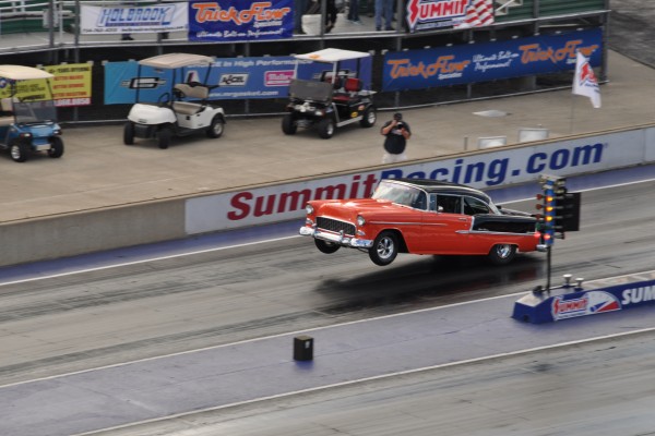 1955 chevy bel air drag car doing a wheelstand at launch