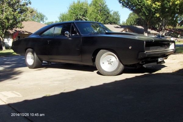 black 1968 dodge charger restomod in home driveway