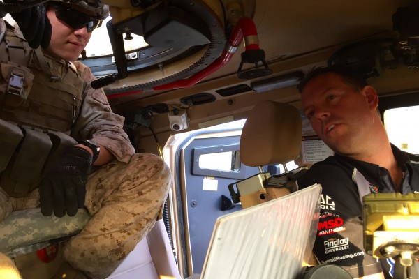 nhra driver in a military vehicle with troops