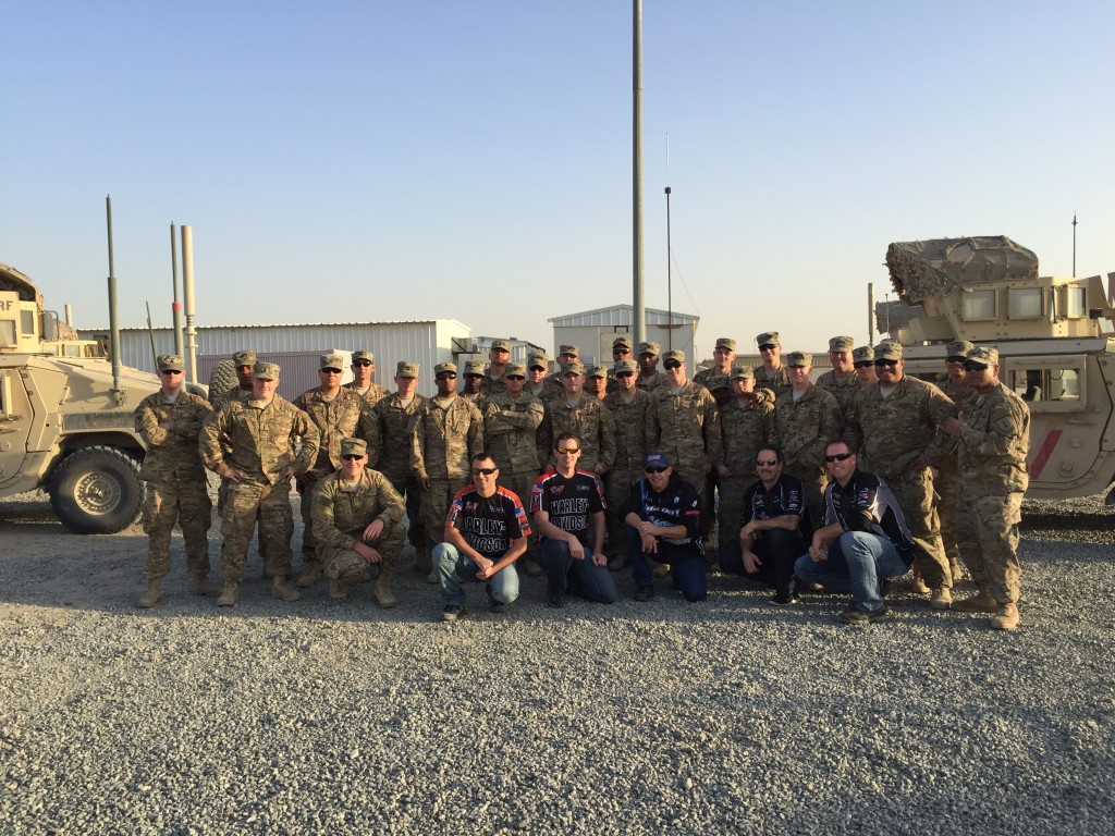 Troops posing with NHRA drivers at military base