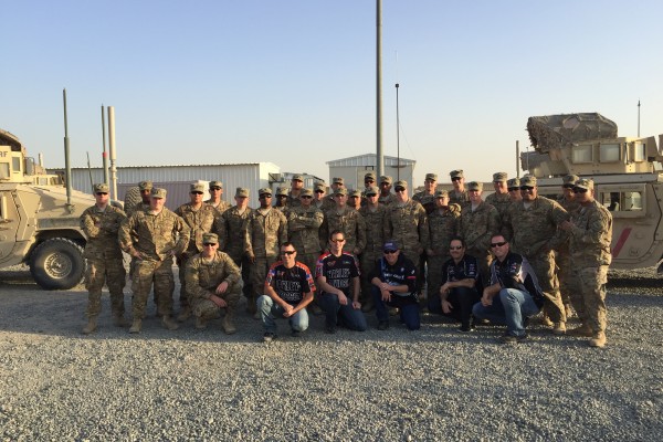 Troops posing with NHRA drivers at military base