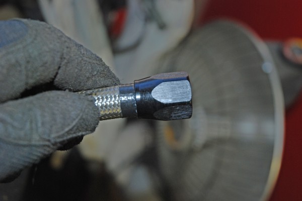 a braided hose fitting end held by man