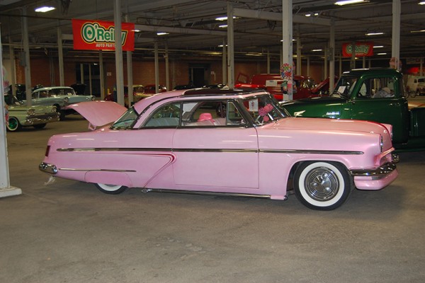pink lowered ford postwar coupe at indoor car show