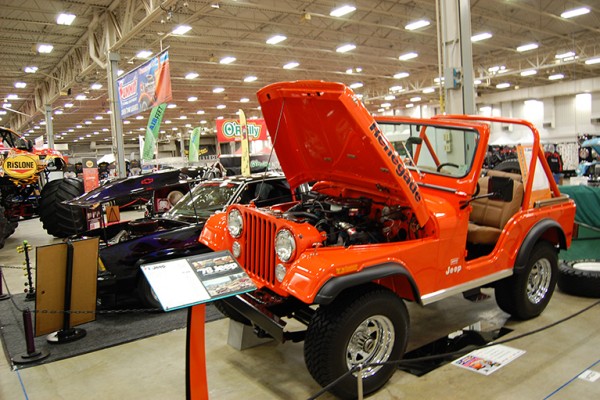 orange jeep cj-5 on display at indoor car show