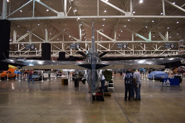military aircraft on display at indoor car show