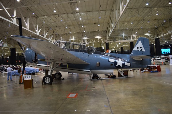 military aircraft on display at indoor car show
