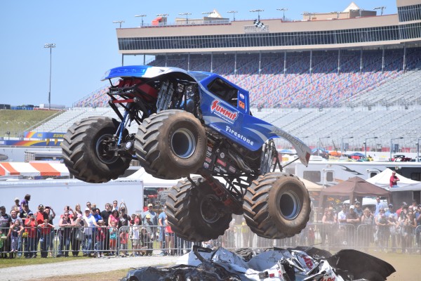 bigfoot monster truck leaping over crushed cars