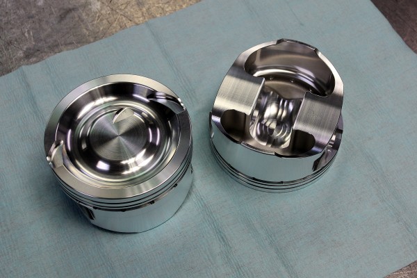 a pair of piston heads on a workbench