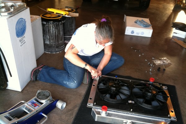 woman prepping radiator prior to install in an AMC AMX