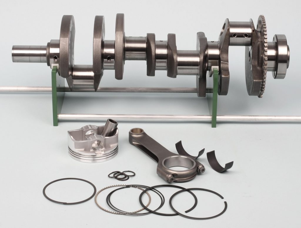 crankshaft, rod, piston, and rings on table