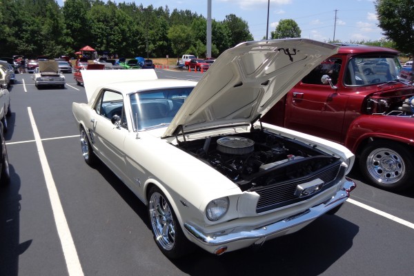 vintage white ford mustang at a car show