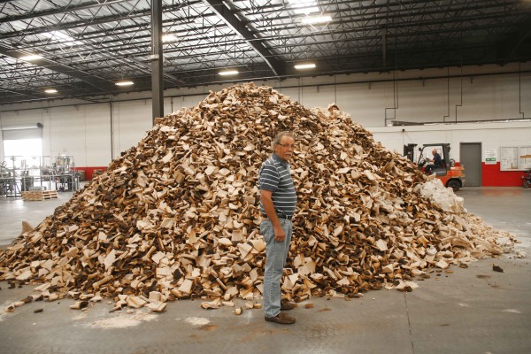 man standing next to pile of large sand cores