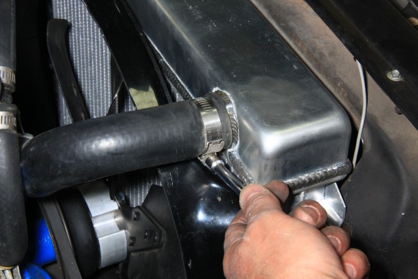 a stainless steel clamp being tightened on a radiator hose