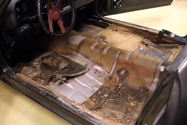 dirty floor of a vintage camaro prior to restoration