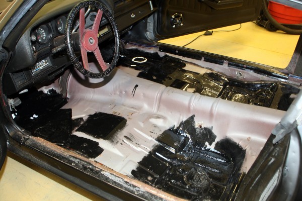 cleaning the floor of a vintage camaro prior to carpet install