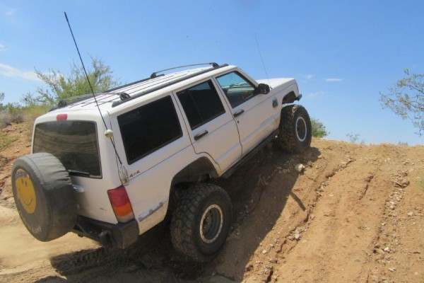 jeep cherokee xj climbing a small dirt ridge