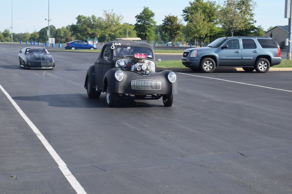 a willys hotrod preparing to race at a dragstrip