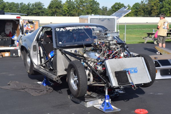 a drag race car being repaired at a drag strip