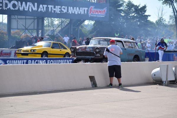 a chevy nomad wagon and ford foxbody mustang racing at a dragstrip