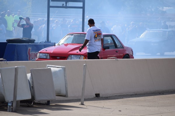 ford mustang foxbody doing a burnout at a dragstrip