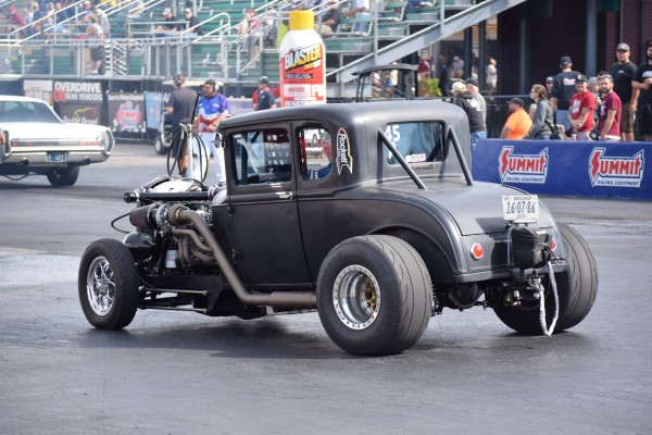 vintage ford hotrowd ith turchared engine at a dragstrip