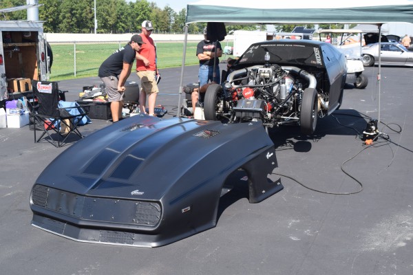 chevy camaro first gen drag car in pits with front clip removed