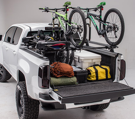 bikes on rack above truck bed loaded with cargo